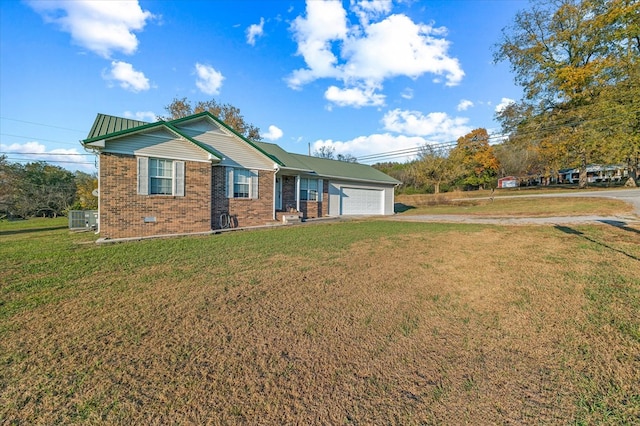 ranch-style home with a garage, a front yard, brick siding, and central air condition unit