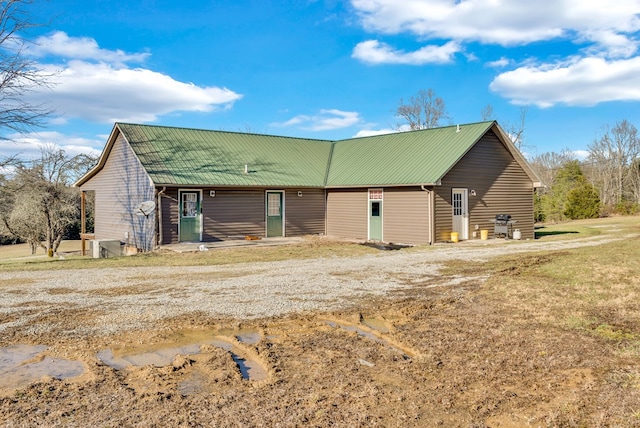 back of house featuring metal roof