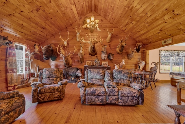 living room featuring wood ceiling, vaulted ceiling, wood walls, a chandelier, and light wood-type flooring