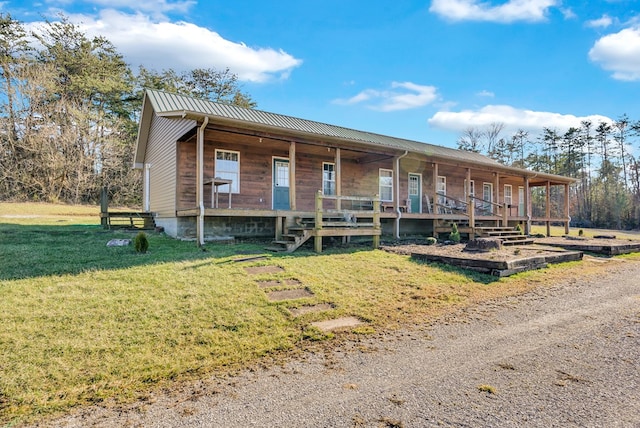 view of front of home featuring metal roof, a porch, and a front lawn