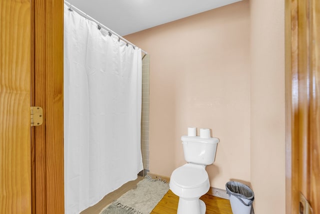 full bathroom with toilet, baseboards, wood finished floors, and a shower with shower curtain