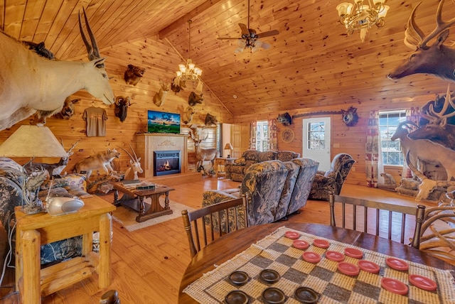 living room featuring wooden ceiling, light wood-style flooring, wooden walls, and a glass covered fireplace