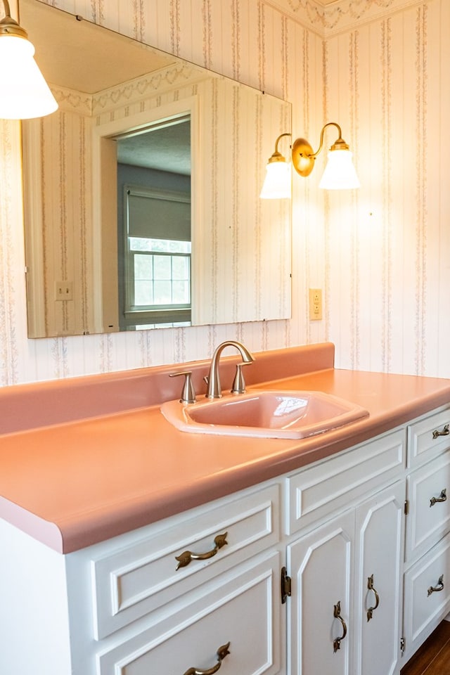 bathroom featuring vanity and wallpapered walls