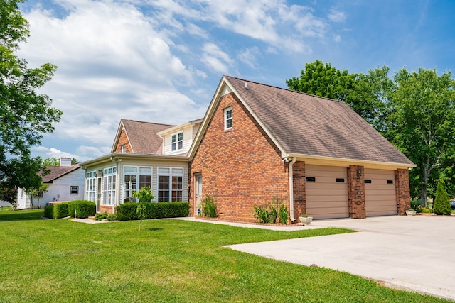 view of front of property featuring driveway, roof with shingles, a front yard, and brick siding