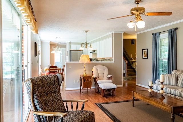 living area with crown molding, stairway, a textured ceiling, and wood finished floors