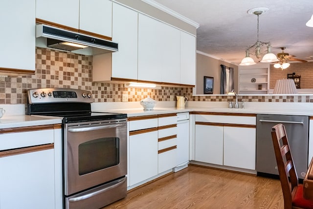 kitchen with white cabinets, under cabinet range hood, pendant lighting, and stainless steel appliances