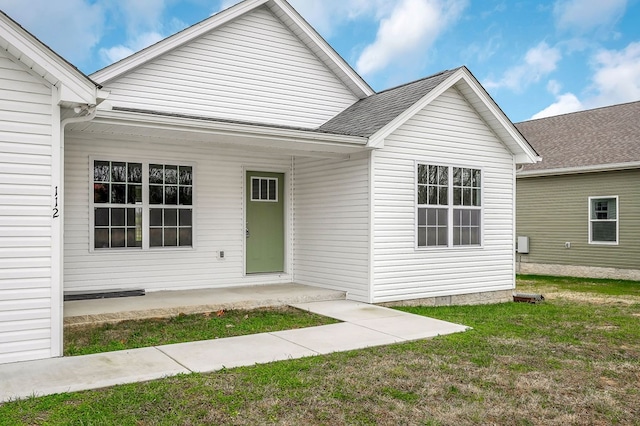 view of front of property with a shingled roof, a front lawn, and a porch