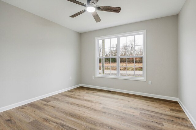 spare room featuring light wood-type flooring, ceiling fan, and baseboards