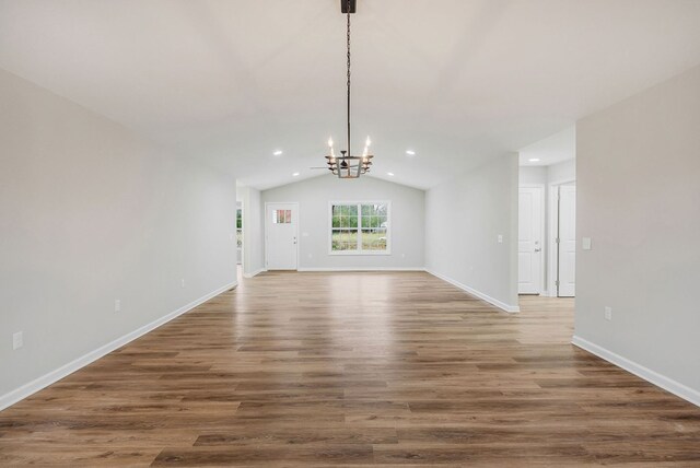 interior space with recessed lighting, a notable chandelier, baseboards, vaulted ceiling, and dark wood finished floors