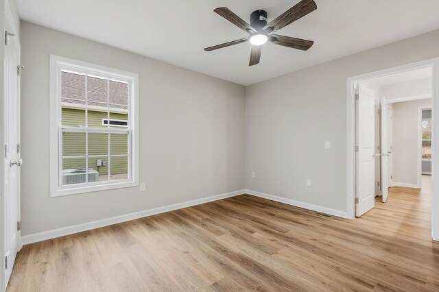 spare room featuring light wood-style floors, baseboards, and a ceiling fan