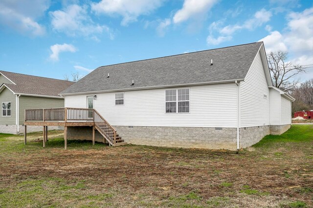 rear view of property featuring roof with shingles, crawl space, stairs, a deck, and a yard