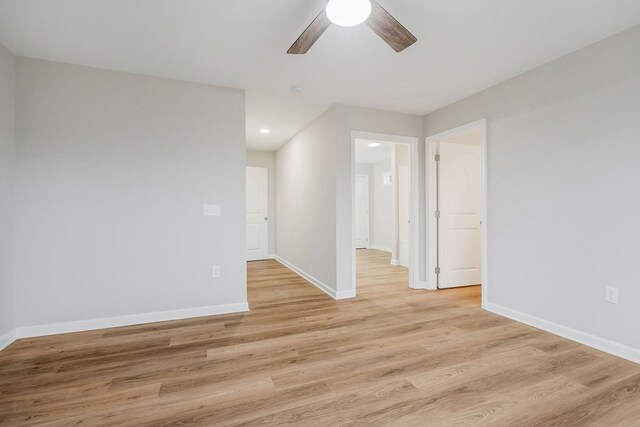 empty room with light wood-style flooring, baseboards, and a ceiling fan