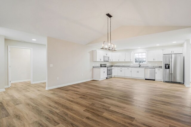 kitchen featuring white cabinetry, stainless steel appliances, light countertops, and decorative light fixtures