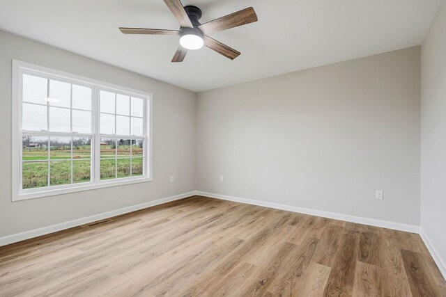 empty room with light wood-style floors, baseboards, visible vents, and ceiling fan