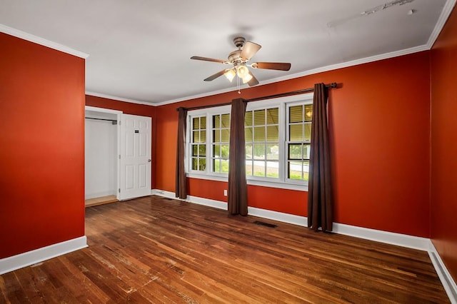 unfurnished room with visible vents, baseboards, a ceiling fan, dark wood-style flooring, and crown molding