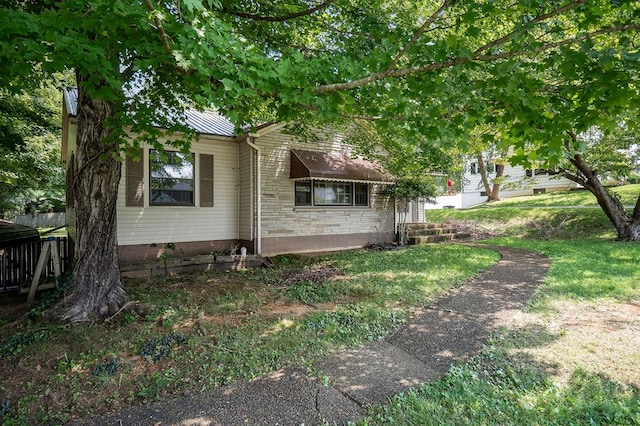 view of property exterior featuring stone siding and a yard