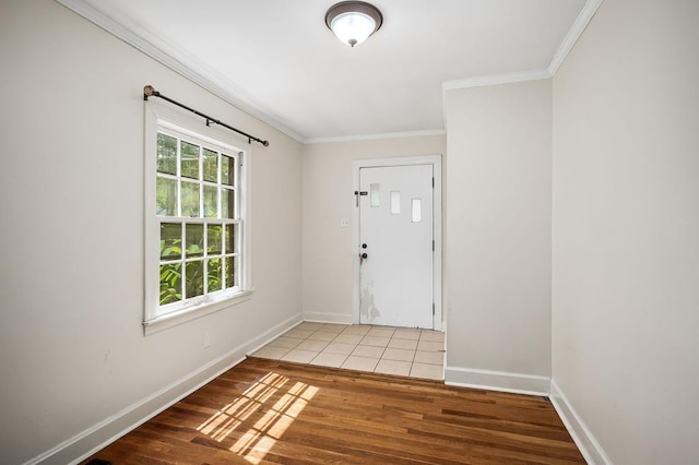 foyer entrance with ornamental molding, baseboards, and wood finished floors