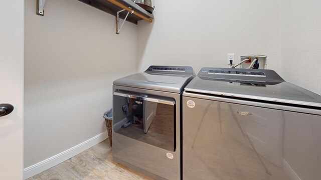 laundry room featuring light wood-type flooring, laundry area, baseboards, and separate washer and dryer