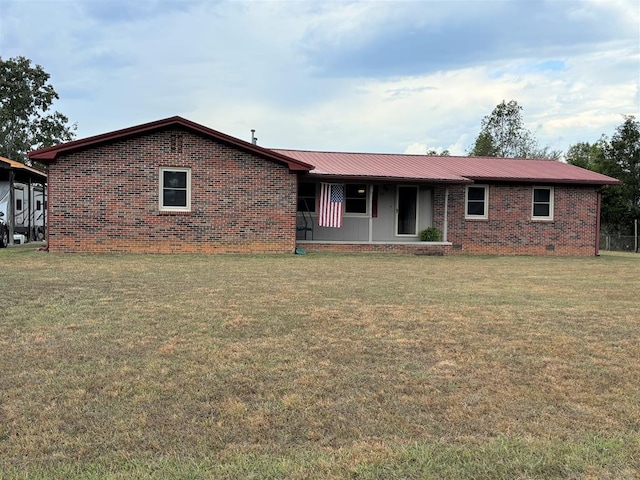 ranch-style home featuring brick siding, metal roof, and a front lawn