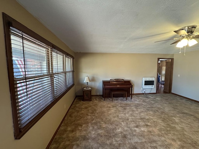 sitting room featuring heating unit, carpet, baseboards, and a textured ceiling