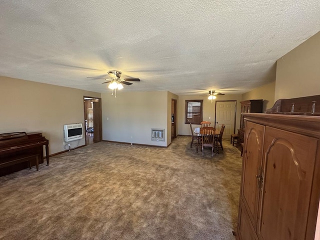 carpeted living area featuring a ceiling fan, baseboards, a textured ceiling, and heating unit