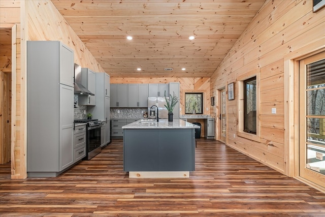 kitchen featuring gray cabinetry, wood ceiling, appliances with stainless steel finishes, wall chimney exhaust hood, and dark wood finished floors