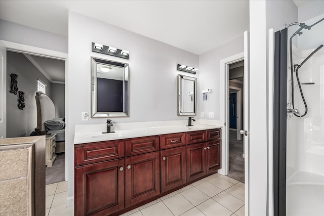 bathroom featuring double vanity, walk in shower, a sink, and tile patterned floors