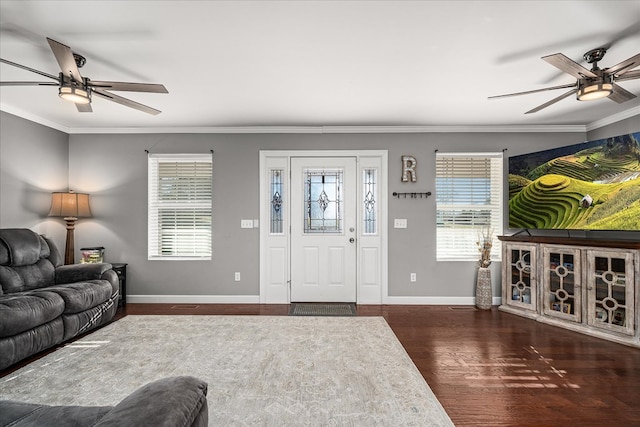 living area with ornamental molding, a ceiling fan, baseboards, and wood finished floors