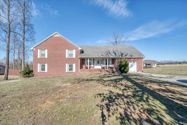 split level home featuring a front lawn, covered porch, brick siding, and an attached garage