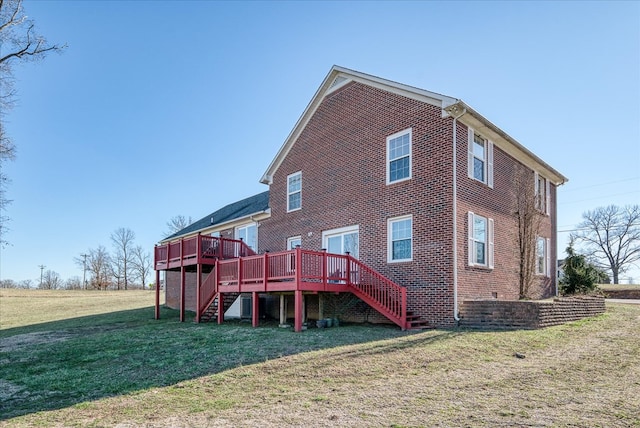 rear view of house featuring brick siding, a wooden deck, stairs, and a yard