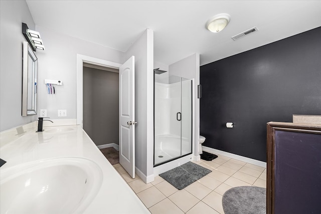 bathroom featuring double vanity, a stall shower, a sink, and tile patterned floors