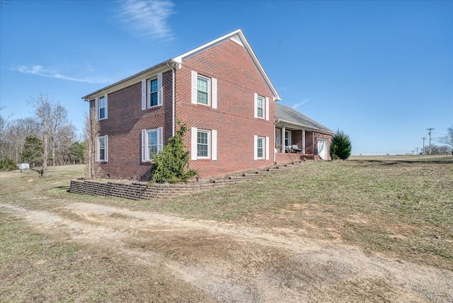 view of property exterior featuring a yard and brick siding