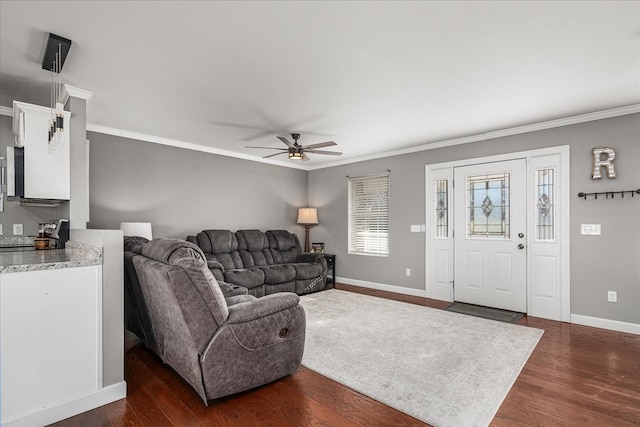 living area featuring dark wood-style floors, ceiling fan, baseboards, and crown molding