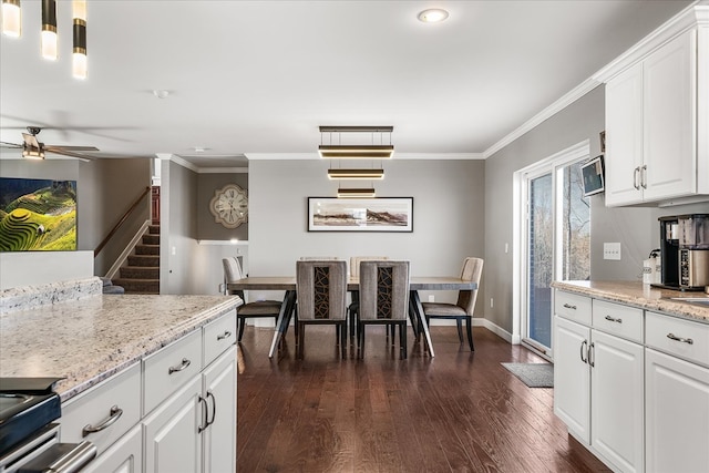 kitchen with baseboards, dark wood-style floors, ceiling fan, ornamental molding, and white cabinetry