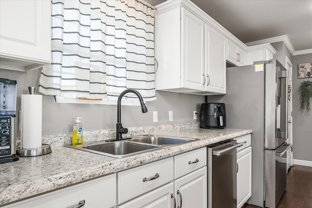 kitchen with dark wood-style flooring, a sink, white cabinetry, light countertops, and ornamental molding