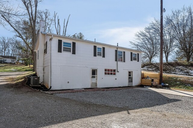 view of front of home featuring a chimney and central AC unit