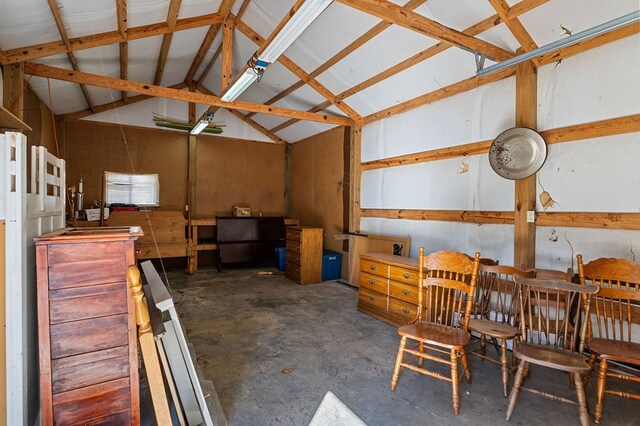 miscellaneous room featuring vaulted ceiling and unfinished concrete floors