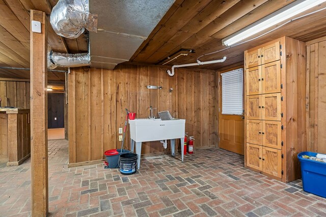 finished basement featuring brick floor and wooden walls