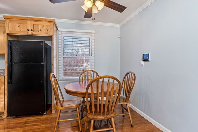 dining space with ceiling fan, ornamental molding, wood finished floors, and baseboards