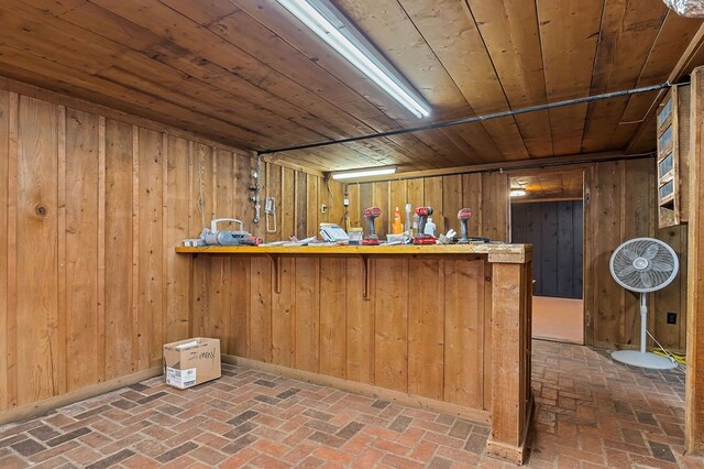 bar featuring wood walls, brick floor, and wood ceiling