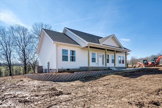 view of front of property with crawl space, a porch, cooling unit, and roof with shingles