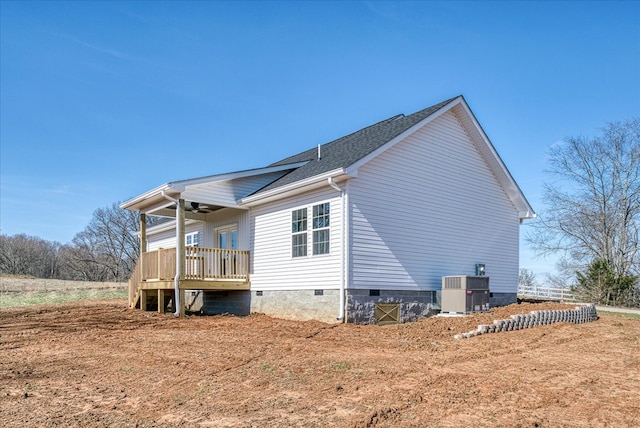 view of side of home featuring crawl space, covered porch, central air condition unit, and roof with shingles