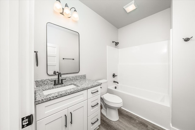 bathroom featuring shower / bath combination, visible vents, toilet, wood finished floors, and vanity