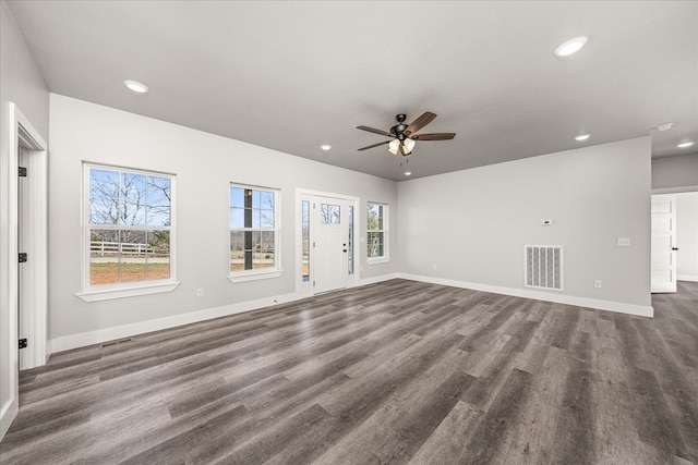 unfurnished living room with dark wood-style flooring, visible vents, and baseboards