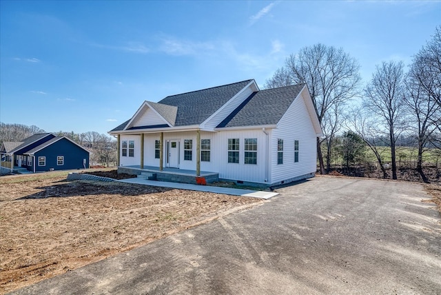 view of front of home with covered porch, roof with shingles, and crawl space