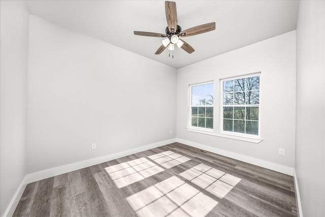 spare room with ceiling fan, baseboards, and wood finished floors