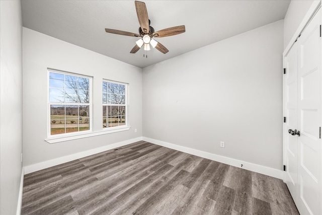 spare room with a ceiling fan, baseboards, and wood finished floors