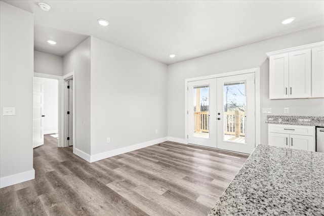 unfurnished dining area with french doors, baseboards, and wood finished floors