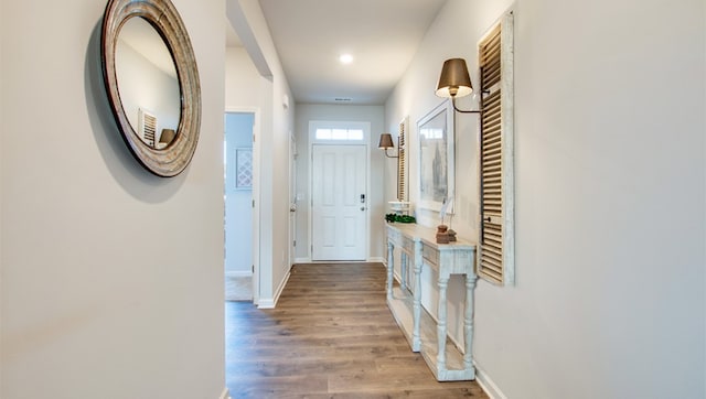 hallway with baseboards and wood finished floors