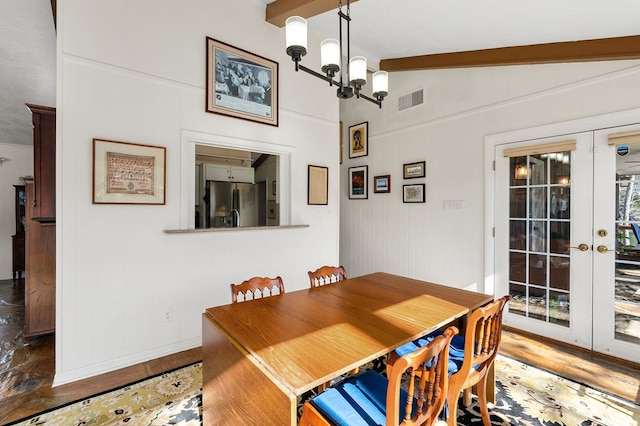 dining space featuring french doors, visible vents, vaulted ceiling with beams, and wood finished floors